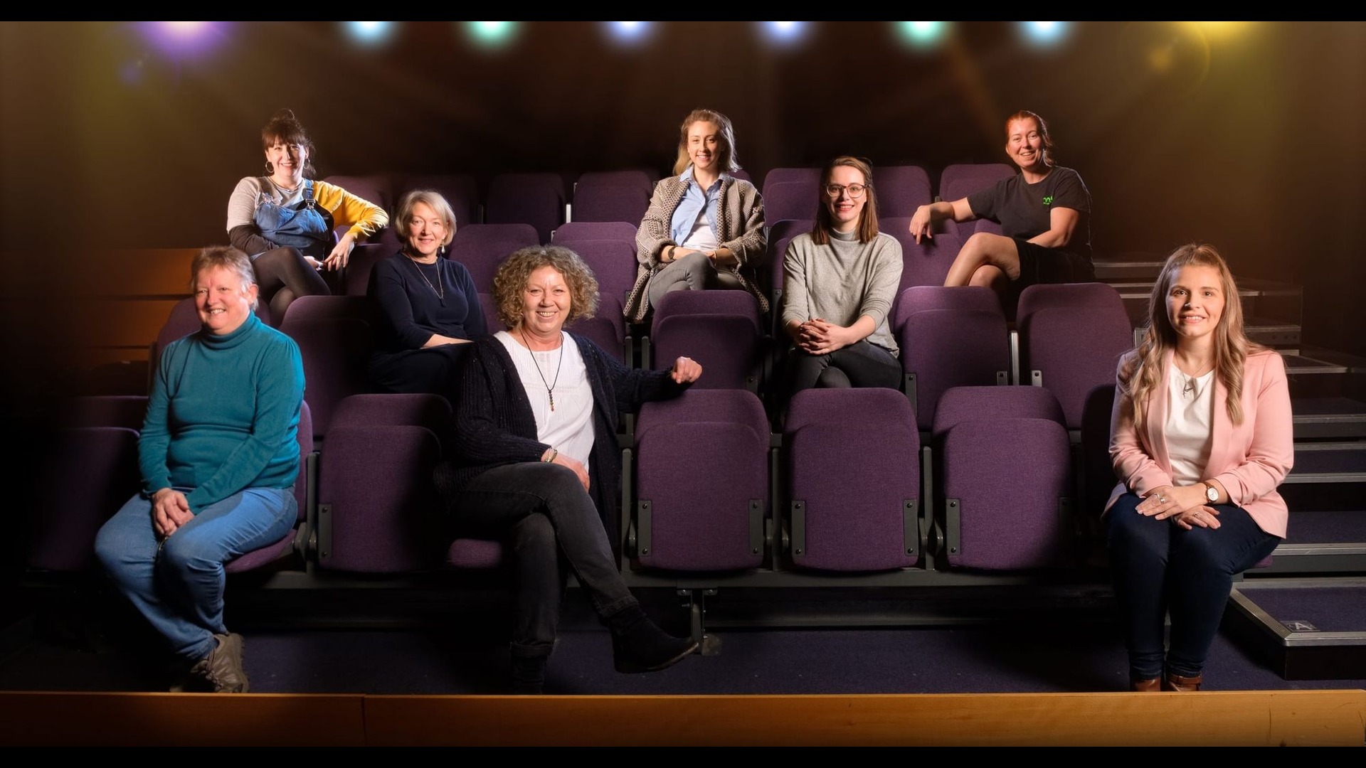 M6 staff members sat on purple foldable theatre seats.