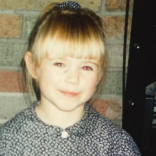 A close up portrait photograph of Lauren Dixon as a child.